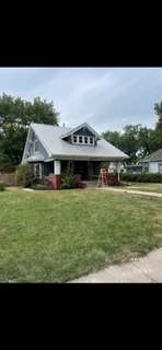 Steep-pitched metal roof with standing seam on modern farmhouse home with gable vents