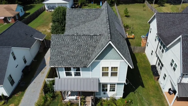 Aerial view of residential home with new gray asphalt shingle roof installation