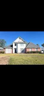 Two-story white house with newly installed asphalt shingle roof and updated flashing