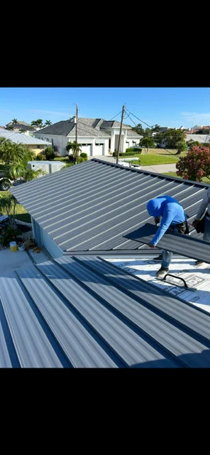 Standing seam metal roof installation with charcoal gray panels and professional seaming